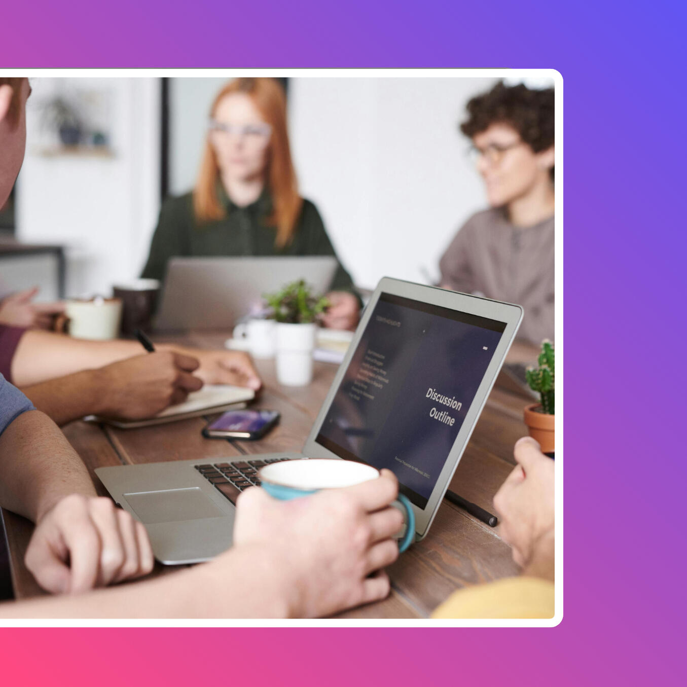 A group of PriceSoft team members working together around a conference table, discussing updates and strategies for price list management software, with a laptop displaying a “Discussion Outline.”